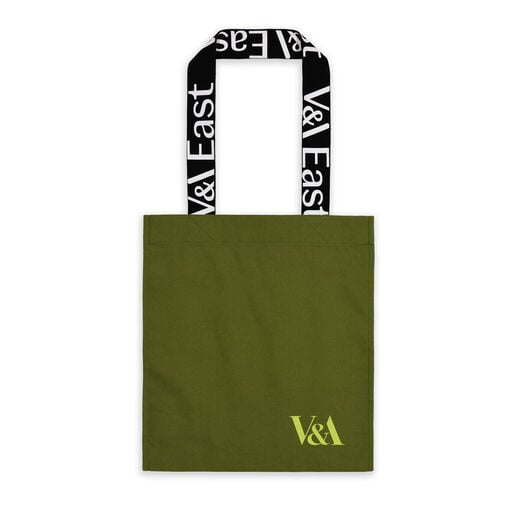 A khaki green tote with graphic typographic handle reading "V&A EAST" - branded for the new V&A EAST Museum and Storehouse